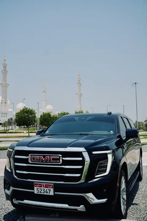 A black GMC Yukon with the Grand Mosque behind