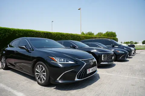 A black Lexus ES at the head of a row of black cars