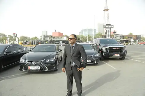 A chauffeur standing in front of a row of black cars