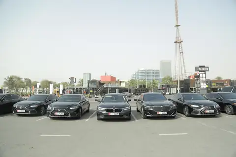 A line of black chauffeur cars in an open car park