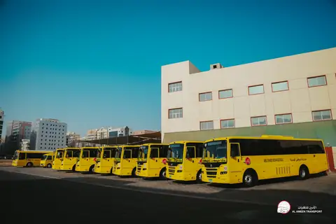 A long line of yellow school buses along the boundary of a school