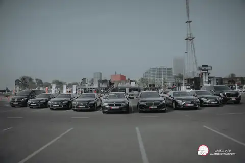 A row of black chauffeur cars in a wide car park