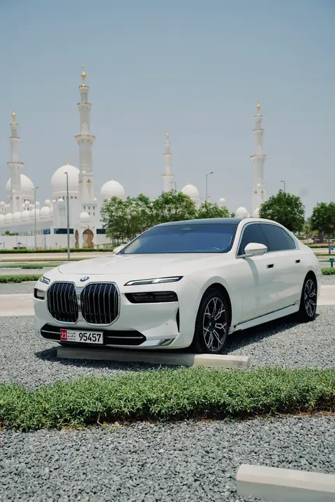 A white BMW 7 Series in front of the Sheikh Zayed Grand Mosque