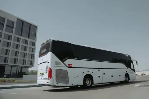 A white coach from the rear, its rear window and engine grille