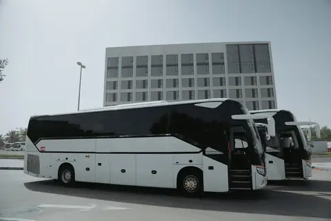 A white coach from the rear quarter, a second coach beside it