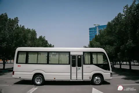 A white minibus from the front quarter with its sliding door to the camera