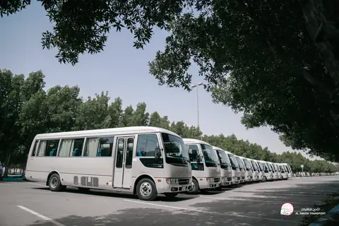 A white minibus in a line, seen from the front quarter
