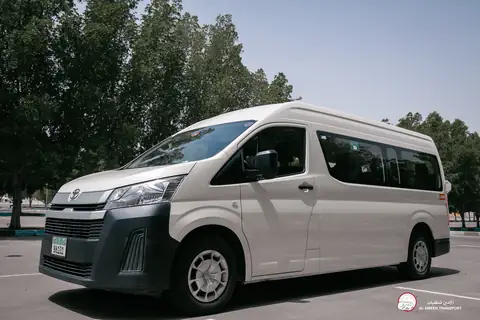 A white van from the front quarter with trees behind