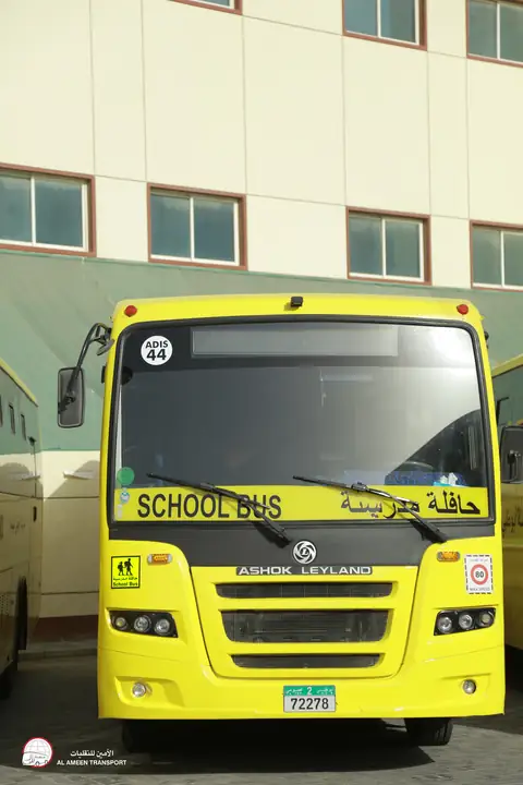 A yellow school bus head-on, its windscreen lettered School Bus