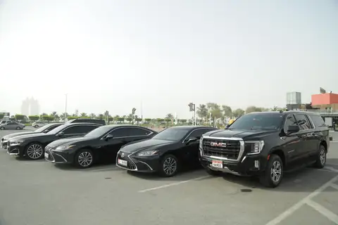 Black Lexus and BMW sedans with a GMC Yukon at the end of the row