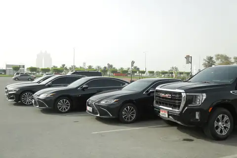 Black sedans and a GMC Yukon parked in a row