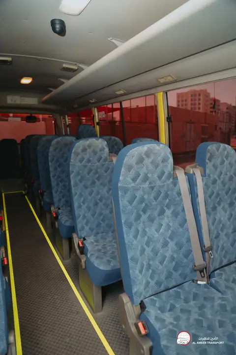 Inside a school bus: blue patterned seats down the aisle