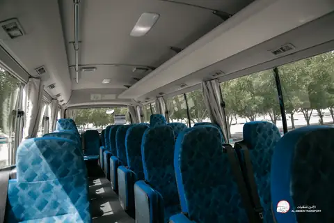 Rows of blue patterned seats inside a minibus