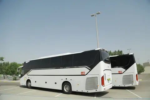 Side view of a white coach parked in the sun