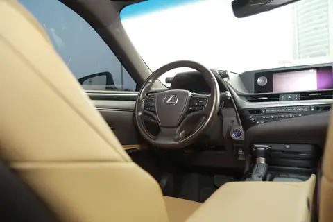 The dashboard and wheel of a Lexus with tan leather