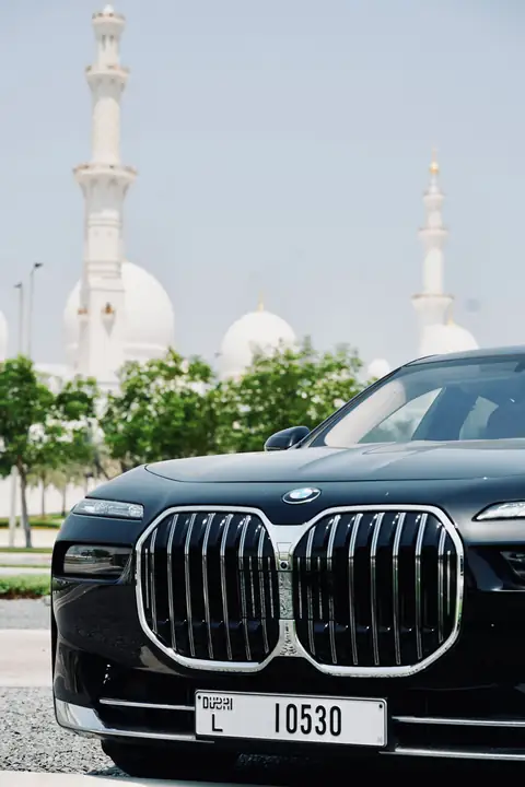 The grille of a black BMW 7 Series with the Sheikh Zayed Grand Mosque behind