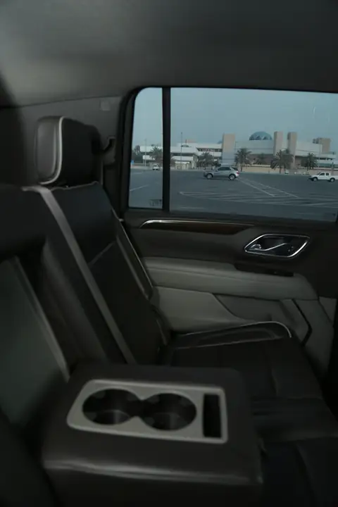 The rear cabin of an SUV with cup holders in the console