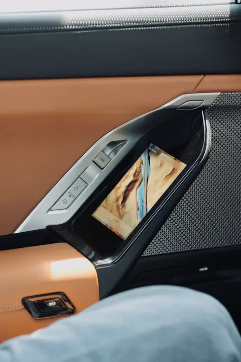 The rear door panel of a BMW 7 Series in tan leather