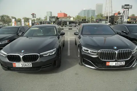 Two black BMW sedans side by side, close up