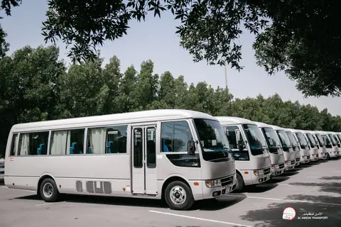 White minibuses lined up, the nearest with its sliding door to the camera