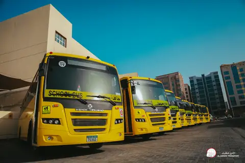 Yellow school buses parked close together, seen from the front quarter